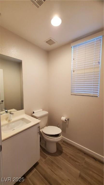 bathroom featuring hardwood / wood-style floors, vanity, and toilet