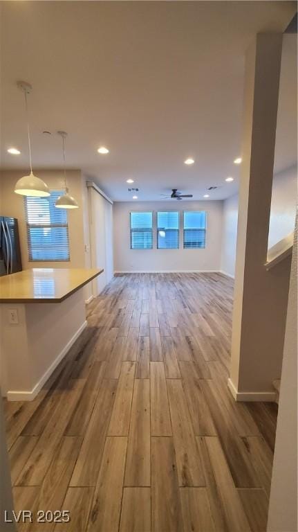 unfurnished living room featuring ceiling fan and light hardwood / wood-style flooring