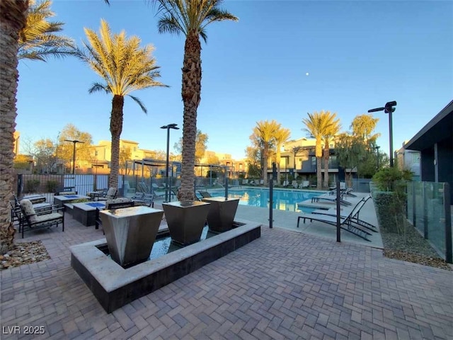 view of patio with a community pool and an outdoor fire pit