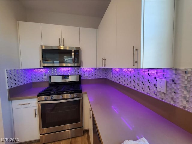 11251 Hidden Peak Ave Unit 212, Las Vegas, NV 89135 - kitchen with backsplash, appliances with stainless steel finishes, and white cabinetry