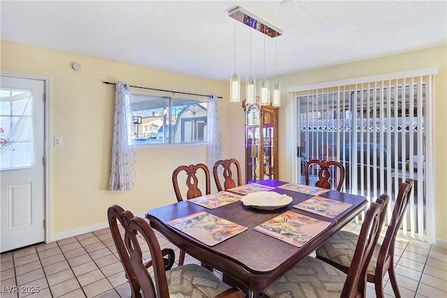 dining room with light tile patterned flooring and a textured ceiling