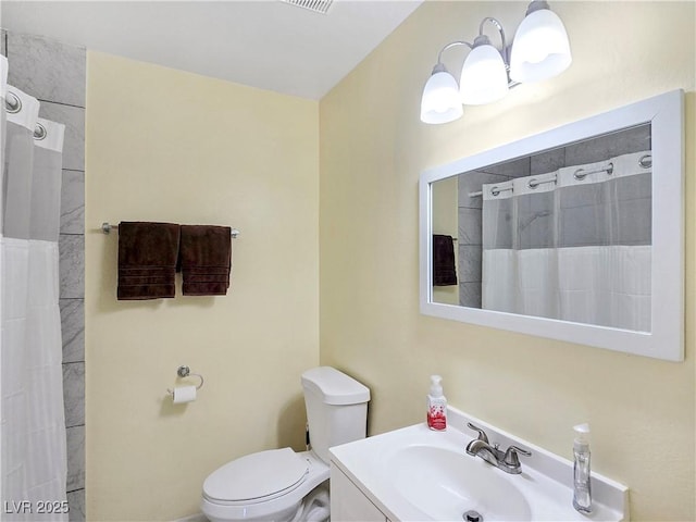 bathroom featuring walk in shower, vanity, and toilet