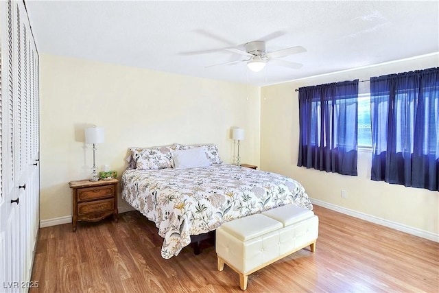 bedroom with ceiling fan, a closet, and wood-type flooring