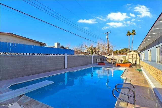 view of pool with a storage unit and a diving board