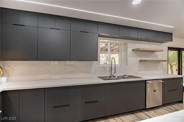 kitchen with tasteful backsplash, sink, light hardwood / wood-style floors, and stainless steel dishwasher