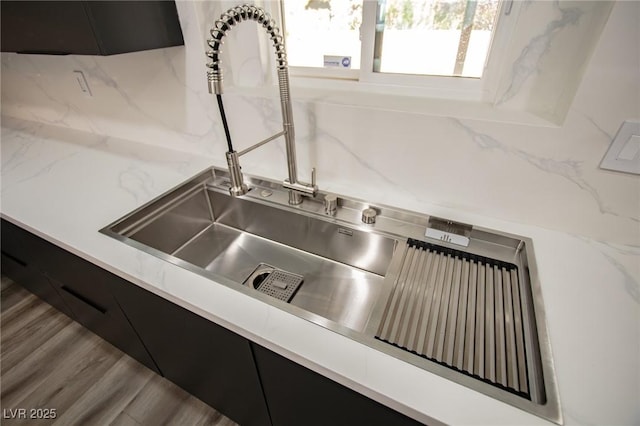 room details with wood-type flooring, tasteful backsplash, and sink