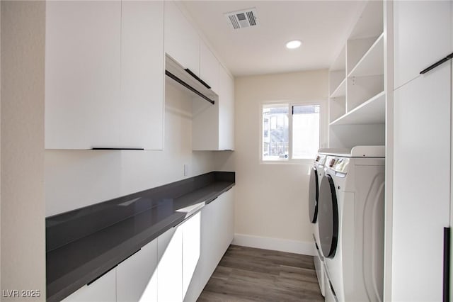 laundry room with independent washer and dryer and dark wood-type flooring