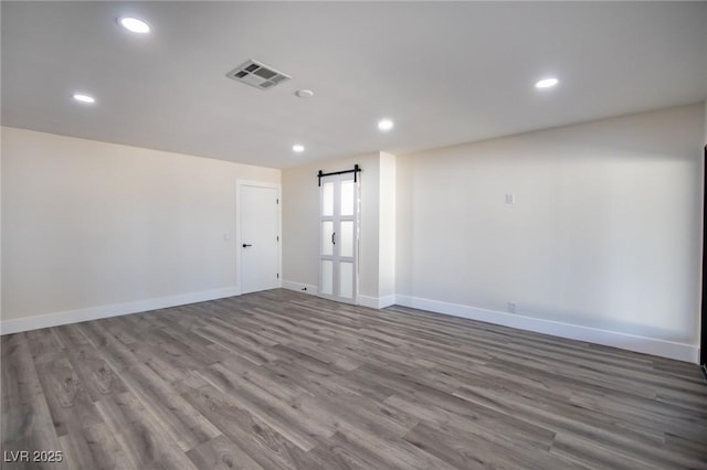 spare room featuring hardwood / wood-style floors and a barn door