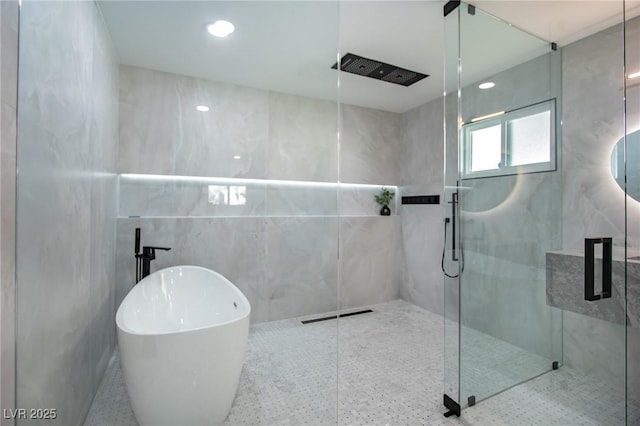 bathroom featuring plus walk in shower and tile walls