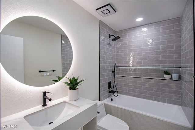 full bathroom with vanity, tiled shower / bath combo, and toilet