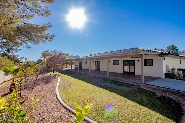 rear view of property featuring a patio, ceiling fan, and a lawn