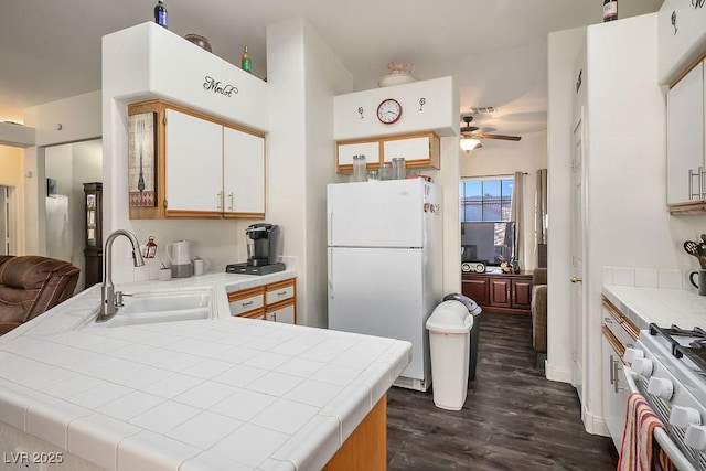 kitchen with white cabinetry, sink, high end stainless steel range oven, white refrigerator, and tile countertops