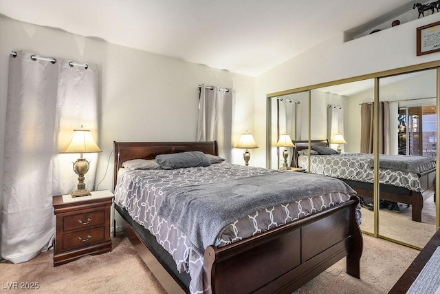 carpeted bedroom featuring a closet and lofted ceiling