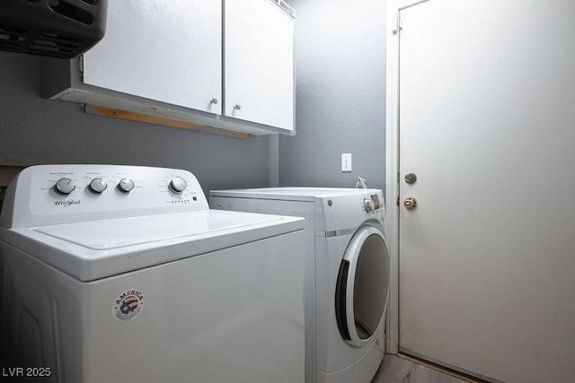 washroom with cabinets, light wood-type flooring, and independent washer and dryer