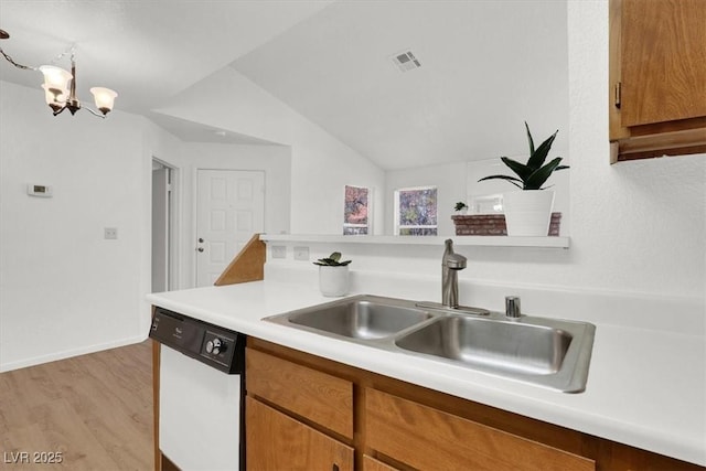 kitchen with lofted ceiling, white dishwasher, sink, light wood-type flooring, and a notable chandelier