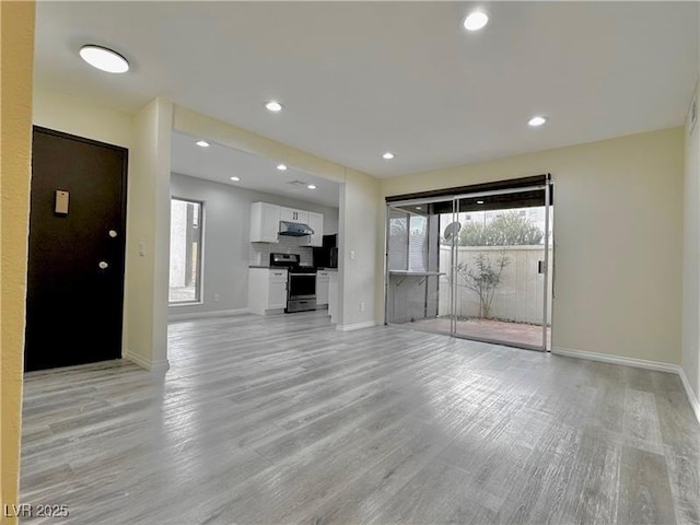 unfurnished living room with plenty of natural light and light hardwood / wood-style floors