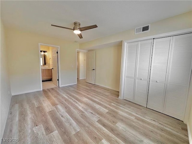 unfurnished bedroom with a closet, ceiling fan, ensuite bath, and light hardwood / wood-style flooring