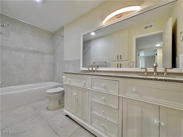 full bathroom featuring tile patterned floors, vanity, toilet, and tiled shower / bath combo