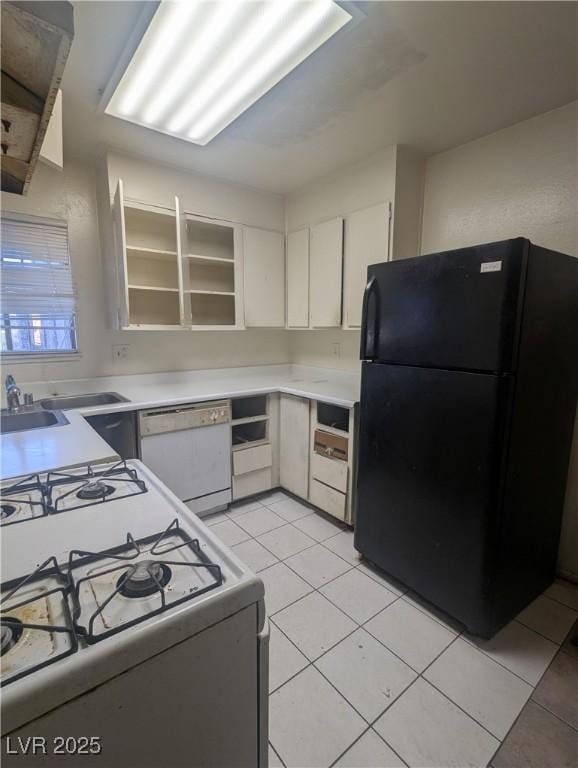 kitchen with white appliances, white cabinetry, and light tile patterned flooring