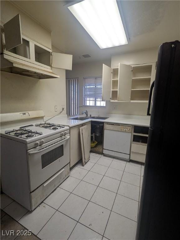 kitchen with white cabinets, sink, light tile patterned floors, and white appliances