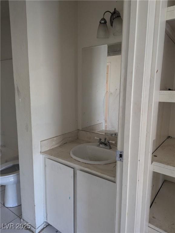 bathroom with tile patterned flooring, vanity, and toilet