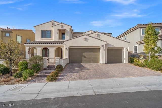 mediterranean / spanish house featuring a garage and covered porch