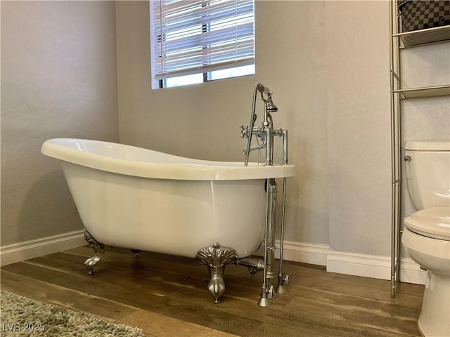 bathroom featuring a washtub, wood-type flooring, and toilet