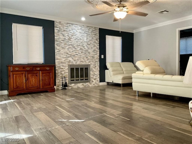 living room featuring a fireplace, hardwood / wood-style flooring, ceiling fan, and ornamental molding