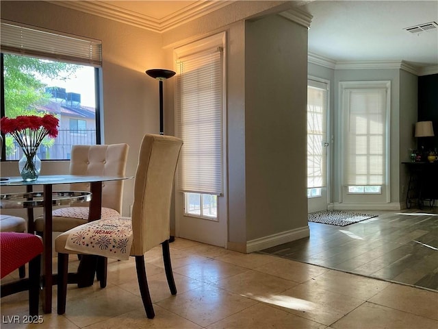 dining space with a wealth of natural light and crown molding