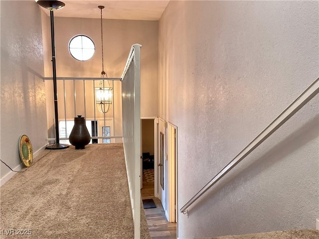 hallway with carpet flooring and a high ceiling