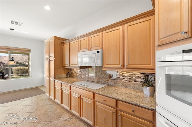 kitchen featuring tasteful backsplash, hanging light fixtures, light tile patterned floors, light stone counters, and white appliances