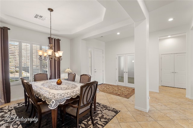 tiled dining room featuring a raised ceiling and an inviting chandelier