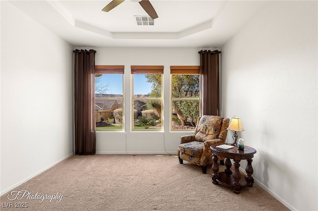 sitting room featuring carpet floors, ceiling fan, and a tray ceiling