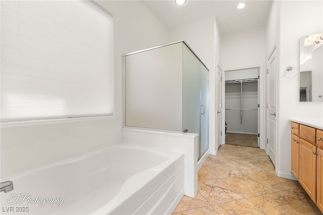 bathroom with vanity and shower with separate bathtub