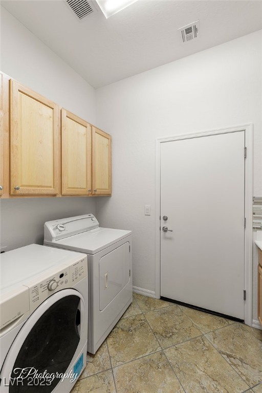 laundry area featuring cabinets and washer and clothes dryer