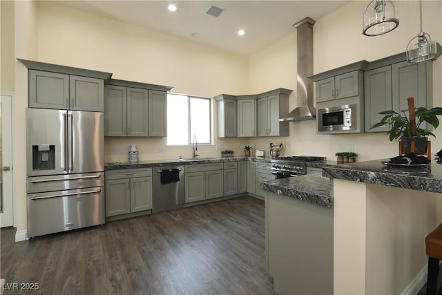 kitchen featuring pendant lighting, sink, a high ceiling, wall chimney range hood, and high end appliances