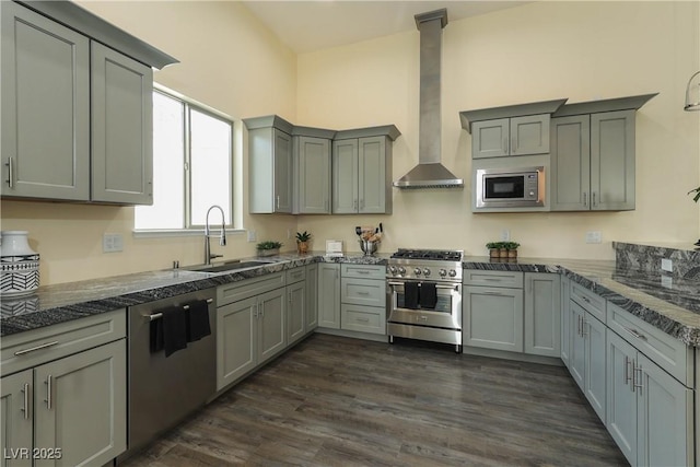 kitchen with wall chimney exhaust hood, stainless steel appliances, sink, dark hardwood / wood-style floors, and gray cabinets