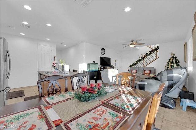 tiled dining area featuring ceiling fan and sink