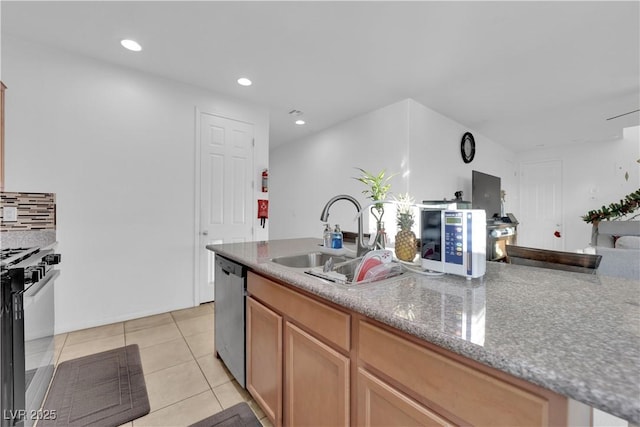 kitchen featuring appliances with stainless steel finishes, light stone counters, light tile patterned floors, and sink