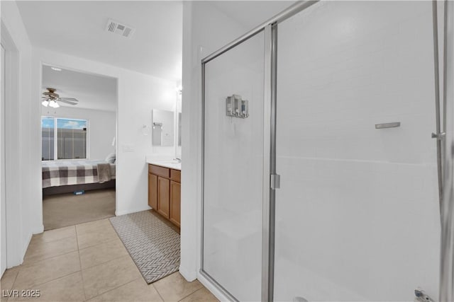 bathroom featuring tile patterned floors, ceiling fan, a shower with door, and vanity