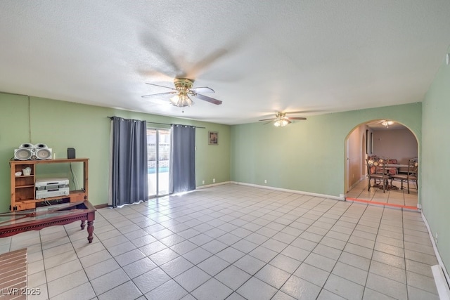 unfurnished room featuring a textured ceiling, ceiling fan, and light tile patterned floors