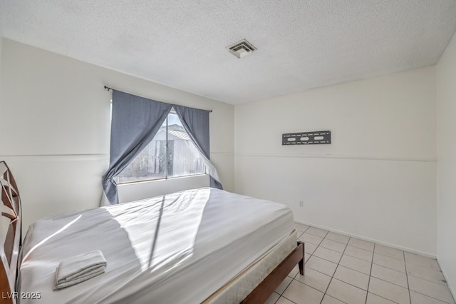 tiled bedroom featuring a textured ceiling