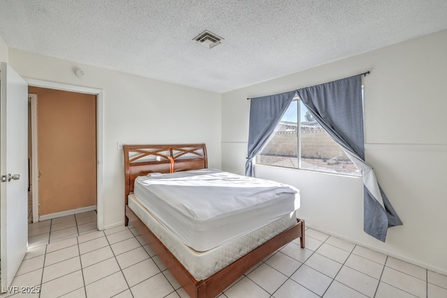 bedroom with a textured ceiling and light tile patterned floors