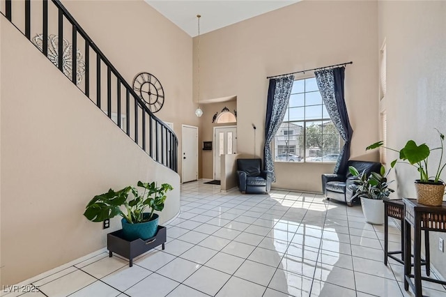 tiled foyer entrance with a towering ceiling