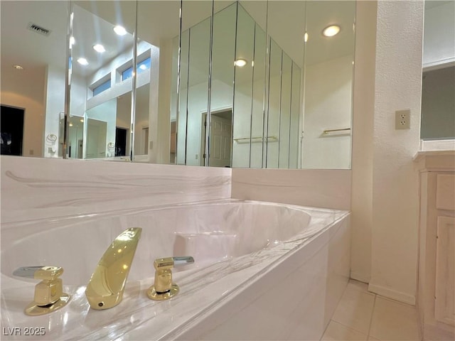 bathroom with tile patterned floors and tiled bath