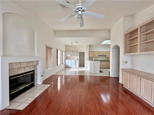 3012 Morning Ridge Dr, Las Vegas, NV 89134 - unfurnished living room featuring light wood finished floors, ceiling fan, and a tile fireplace
