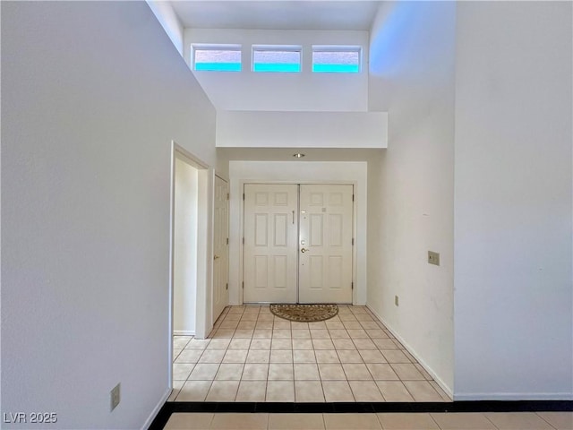 entrance foyer with light tile patterned flooring and a high ceiling