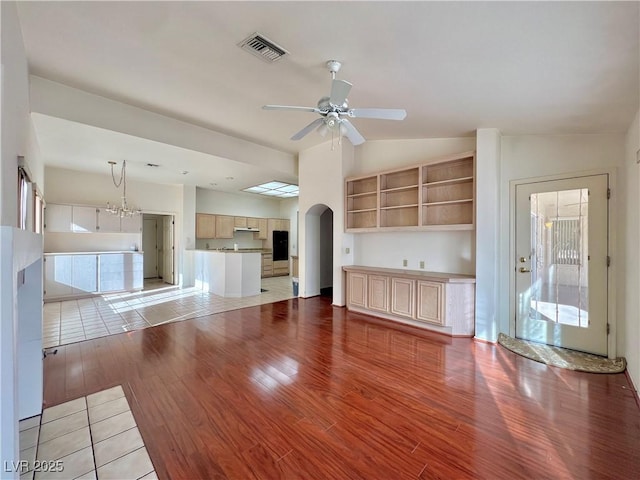 3012 Morning Ridge Dr, Las Vegas, NV 89134 - unfurnished living room with light wood-style floors, arched walkways, ceiling fan, and lofted ceiling