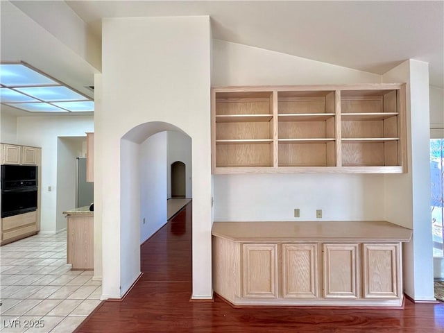 3012 Morning Ridge Dr, Las Vegas, NV 89134 - kitchen with black microwave, light countertops, arched walkways, and vaulted ceiling