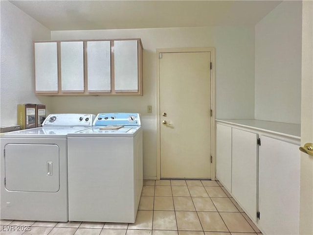 laundry area with cabinets, separate washer and dryer, and light tile patterned floors